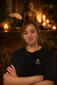 Maria Budzińska, właścicielka gabinetu masażu Dotyk Orientu w Świętoszowie, w orientalnym wnętrzu z świecami i figurką Buddy